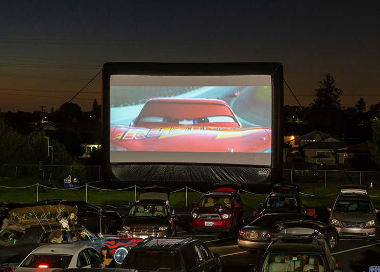 Audience watching cars at a FunFlicks drive-in movie event
