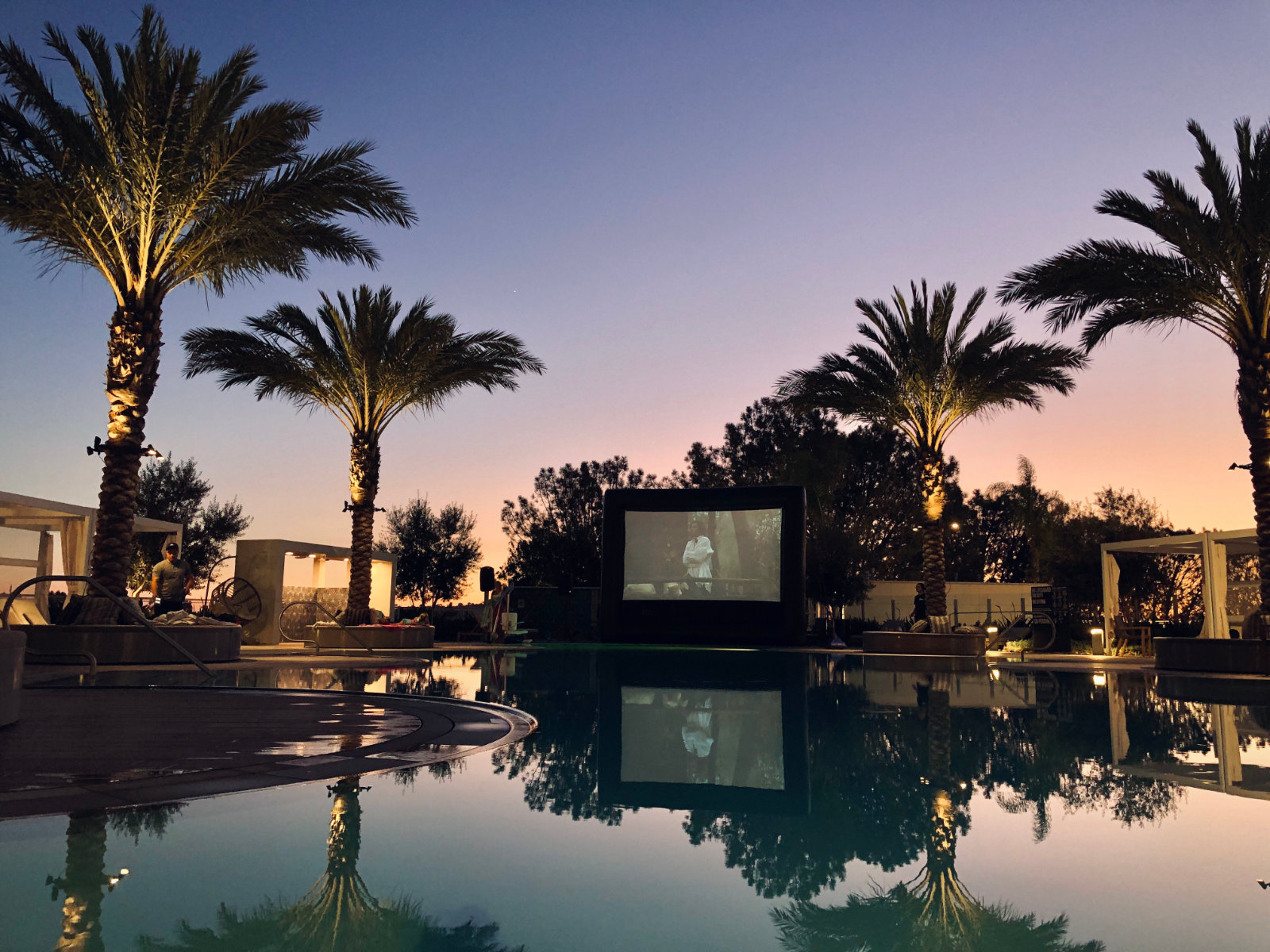 FunFlicks® inflatable screen by the pool at an apartment movie party