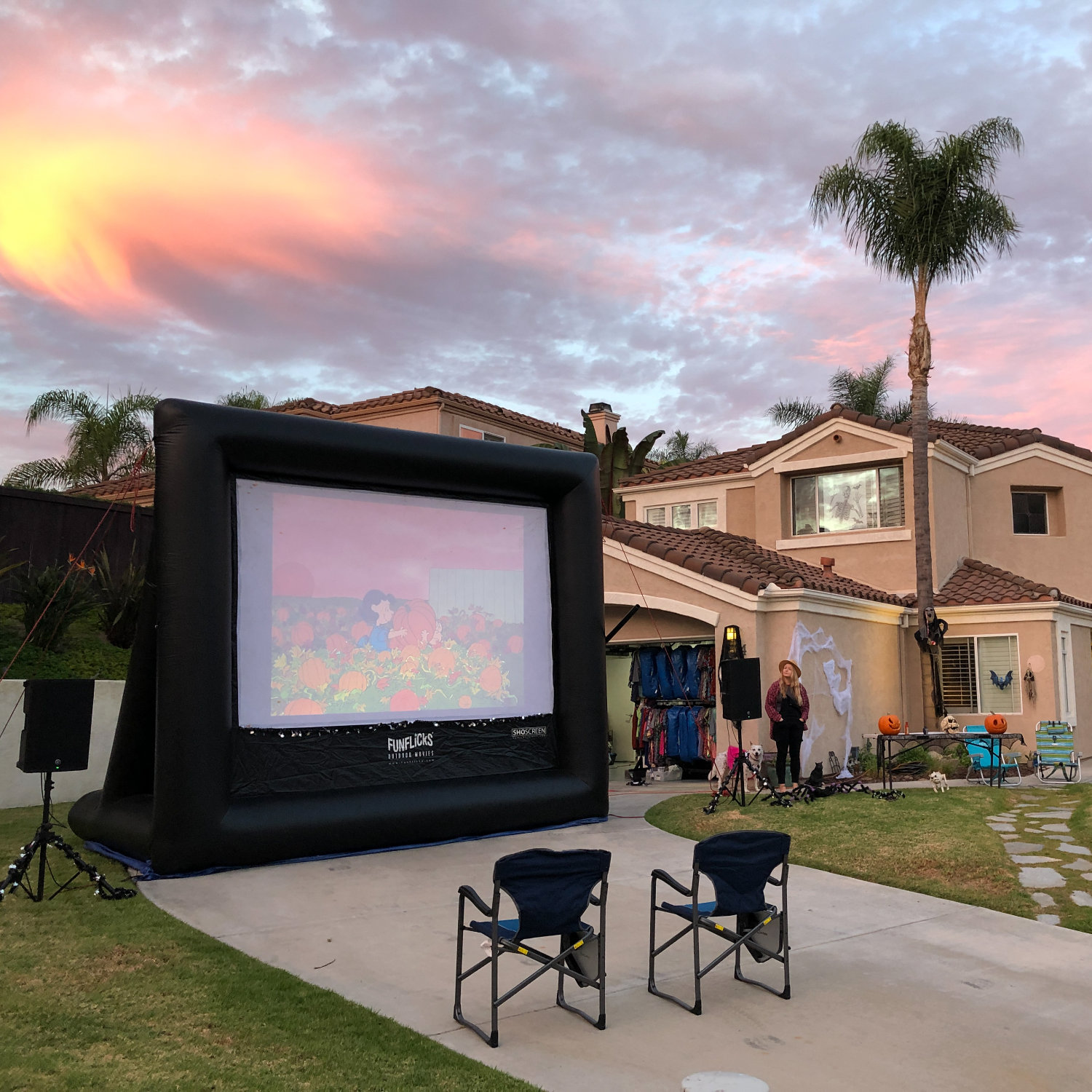Showing a Halloween movie on a FunFlicks inflatable screen in the front yard.