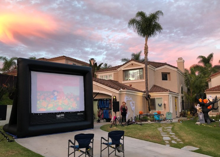 Home decorated for Halloween with a movie projected in the driveway