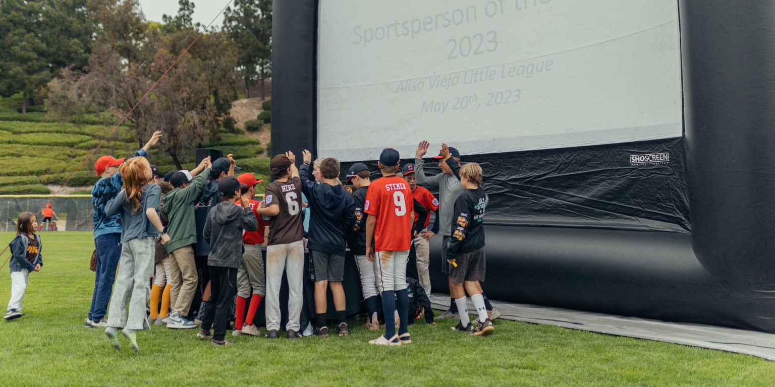 A little league ceremony taking place with a FunFlicks inflatable screen at a local parks and recreation event.