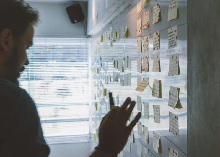 Man planning an event with notes posted on a wall